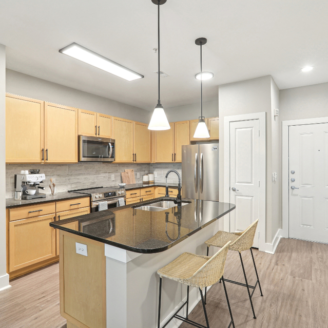 A modern kitchen featuring stainless steel appliances and wooden floors at Porter Westside